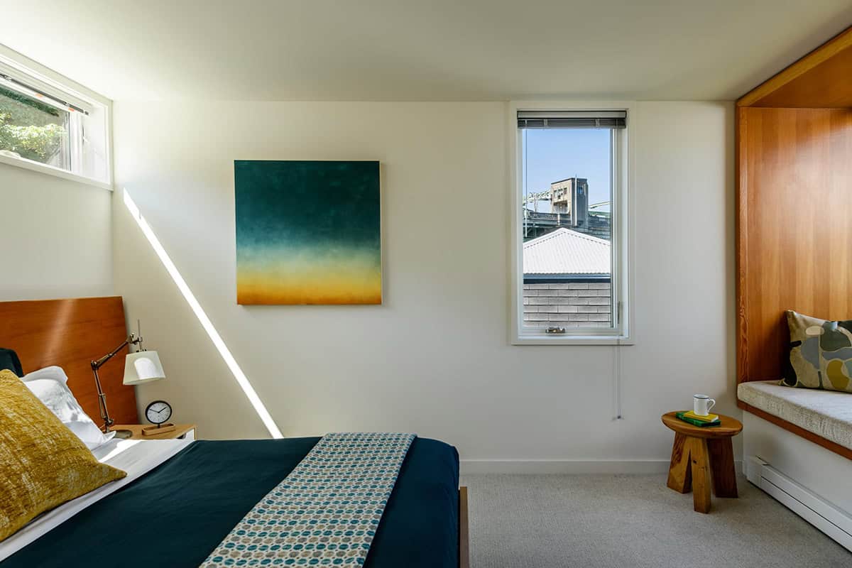 Bedroom with wood window seat, abstract painting, and water views