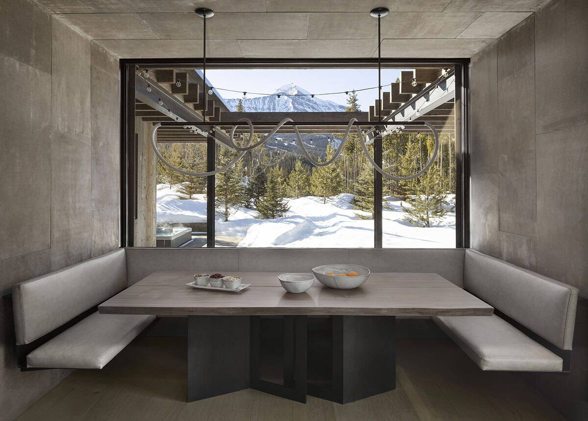 Concrete breakfast nook with U-shaped banquette, sculptural pendant, and snowy Lone Peak views