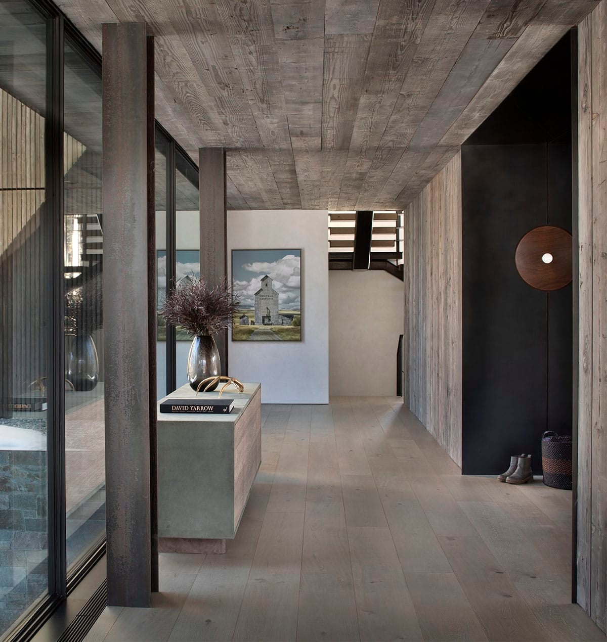 Entry hallway with reclaimed wood ceiling, console table, David Yarrow book, and landscape painting