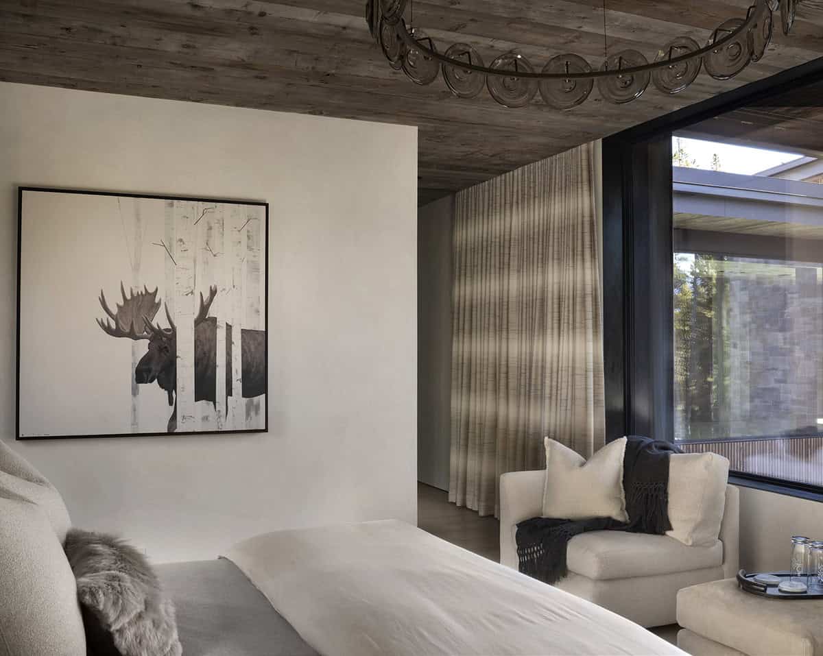 Bedroom with moose painting, linen drapes, white bouclé armchair, and reclaimed wood accent wall