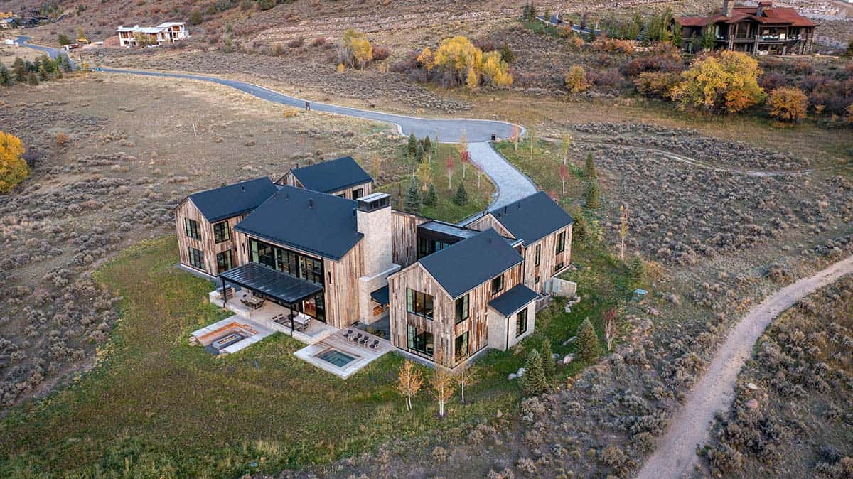 Aerial view of angular reclaimed wood home with hot tub deck and fire pit terrace