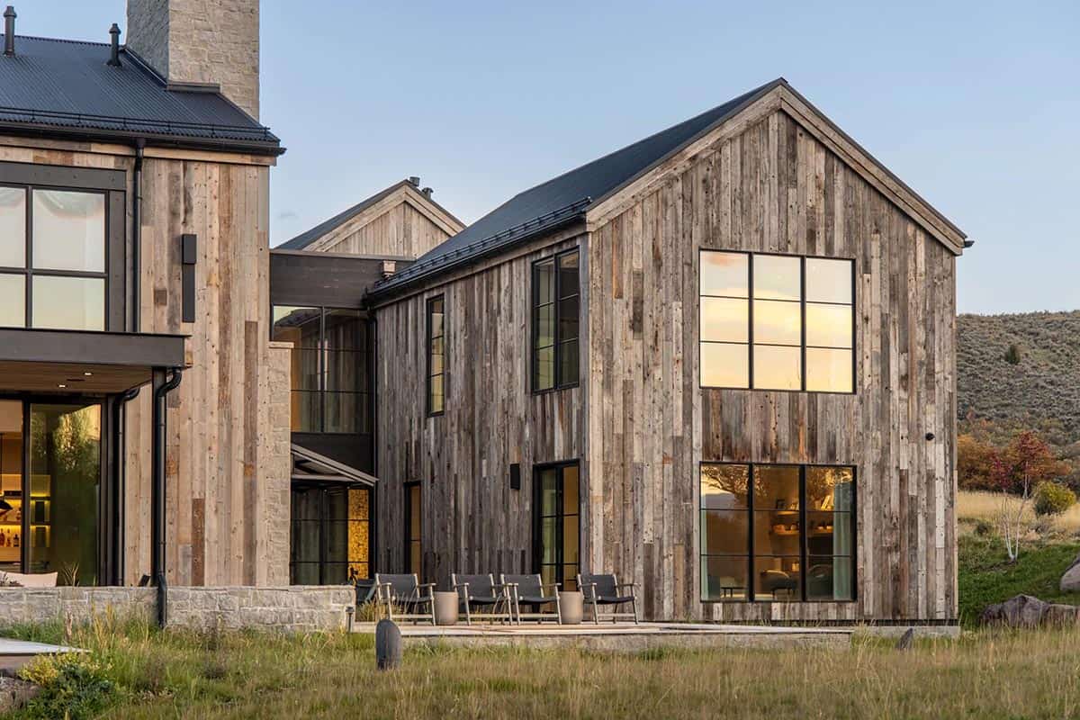 Reclaimed wood wing with oversized steel windows reflecting sunset over Utah landscape