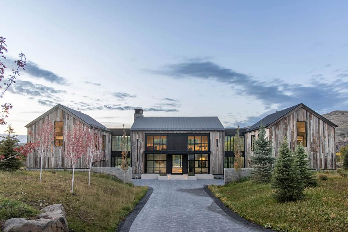 Front entry of reclaimed wood mountain home at dusk with cobblestone approach path