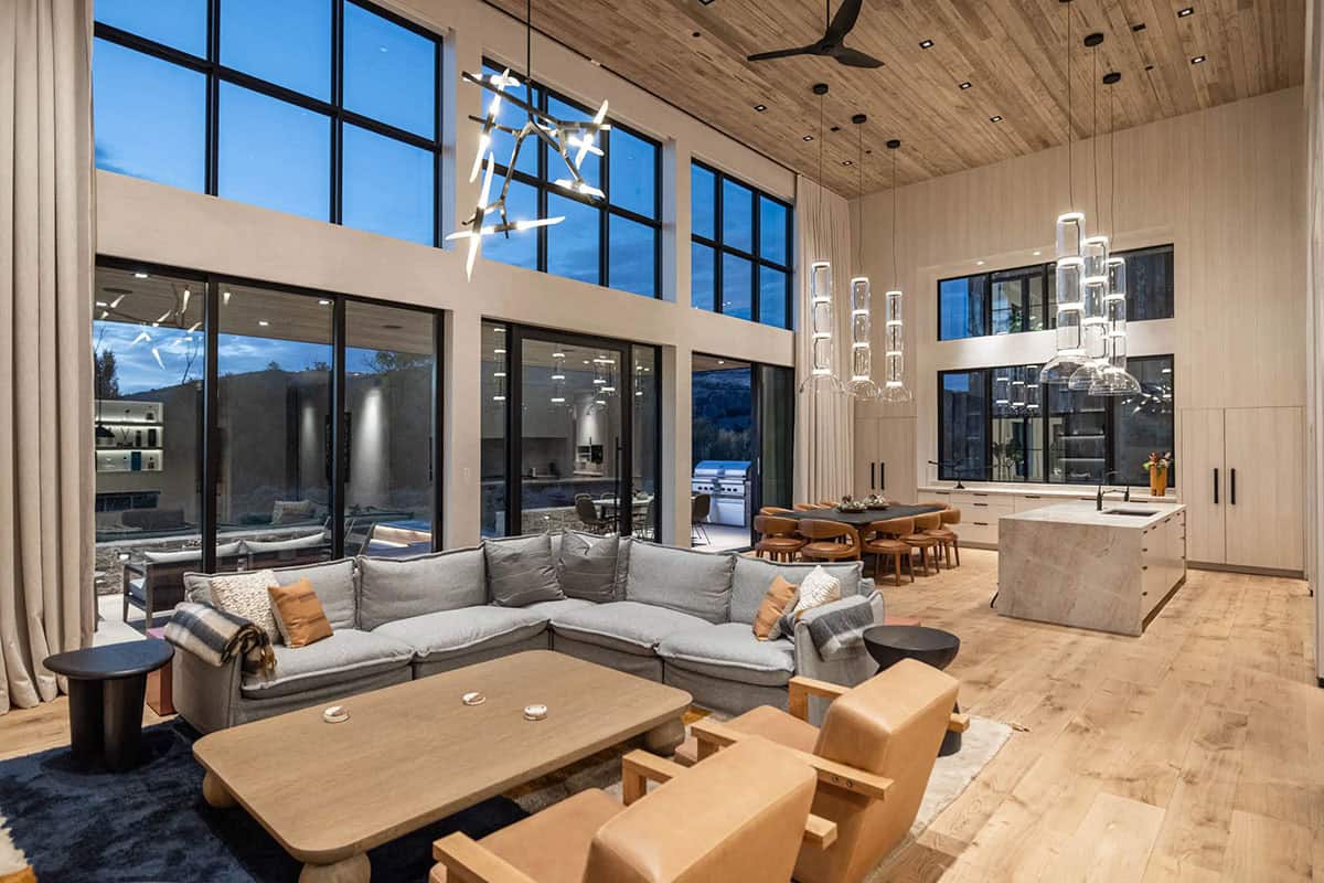 Double-height open plan living and dining room with sculptural pendant lights and floor-to-ceiling windows