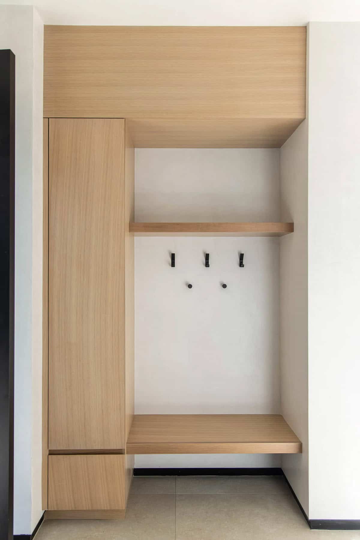 Built-in mudroom nook with white oak bench, shelving, and matte black coat hooks