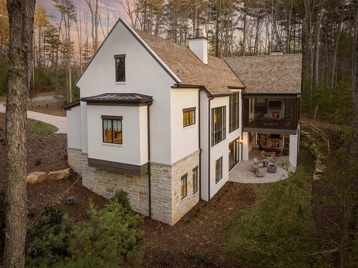 Aerial side view of white stucco home with cedar shake roof and covered outdoor patio