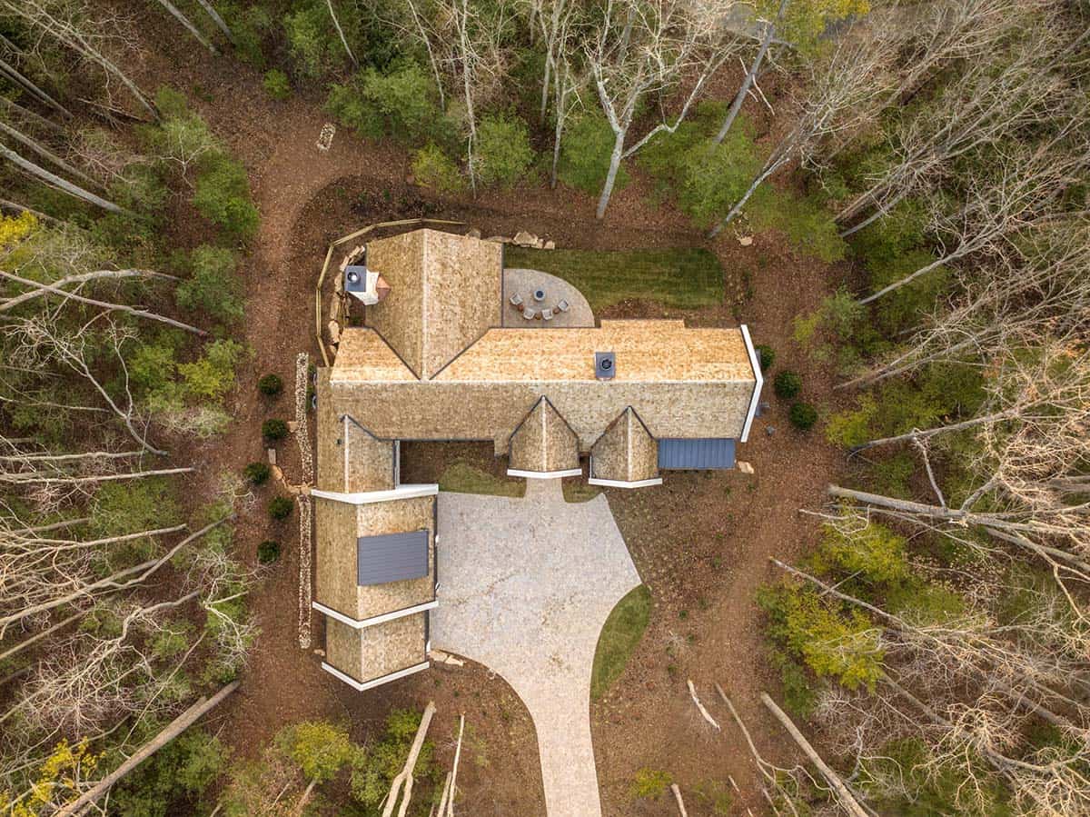 Bird's-eye aerial view of cedar shake roof home nestled in forest clearing