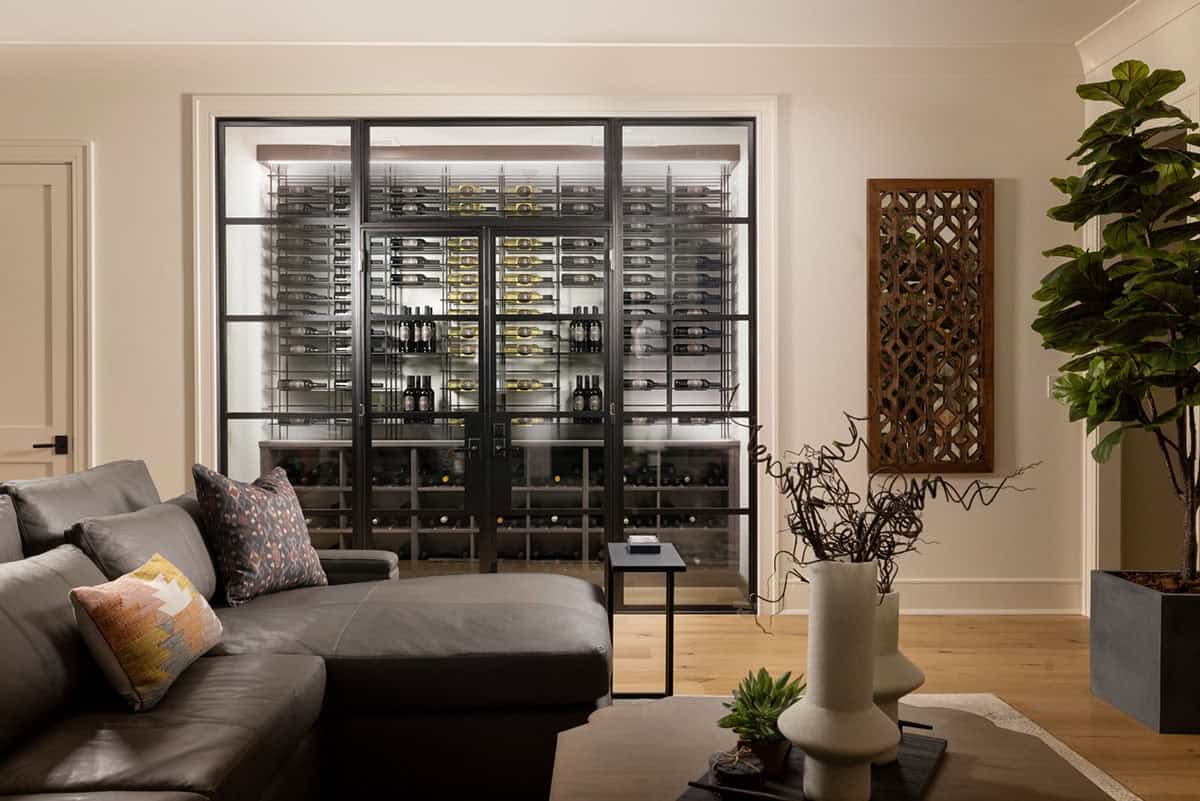 Glass-enclosed wine cellar room viewed from leather sectional seating area