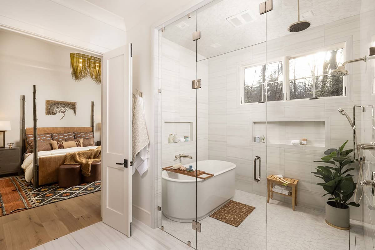 Primary bath with freestanding soaking tub inside glass shower enclosure