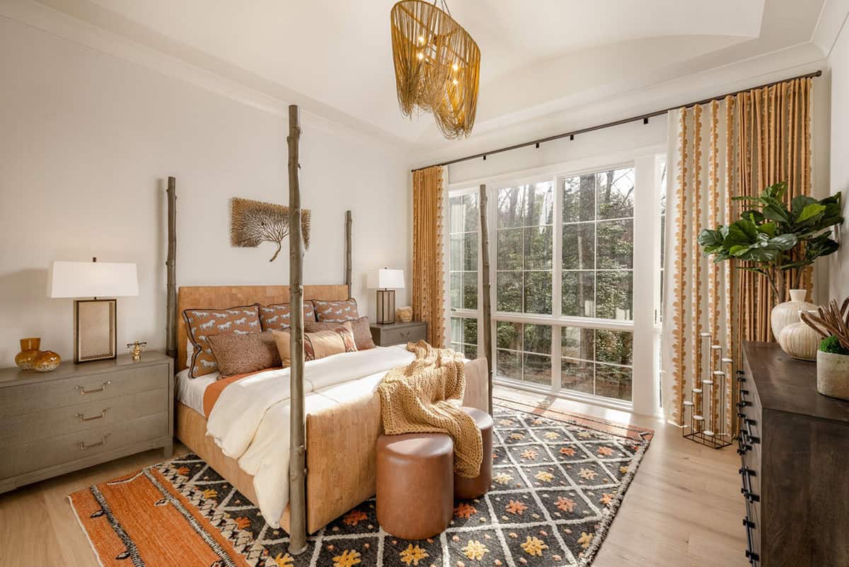 Primary bedroom with rustic branch four-poster bed, woven pendant light, and forest views
