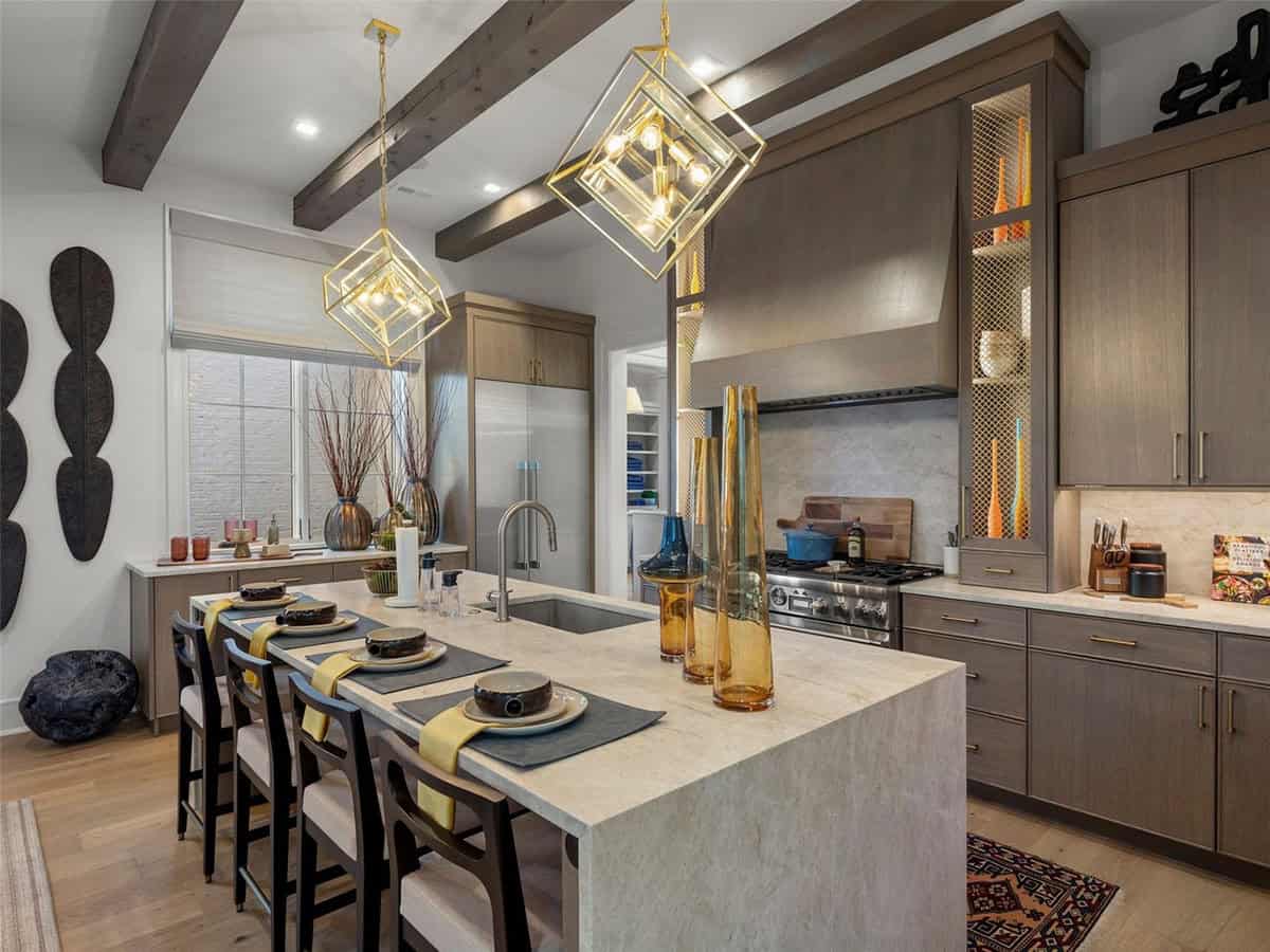 Kitchen island with stone countertop, gold geometric pendant lights, gray cabinets, and professional gas range