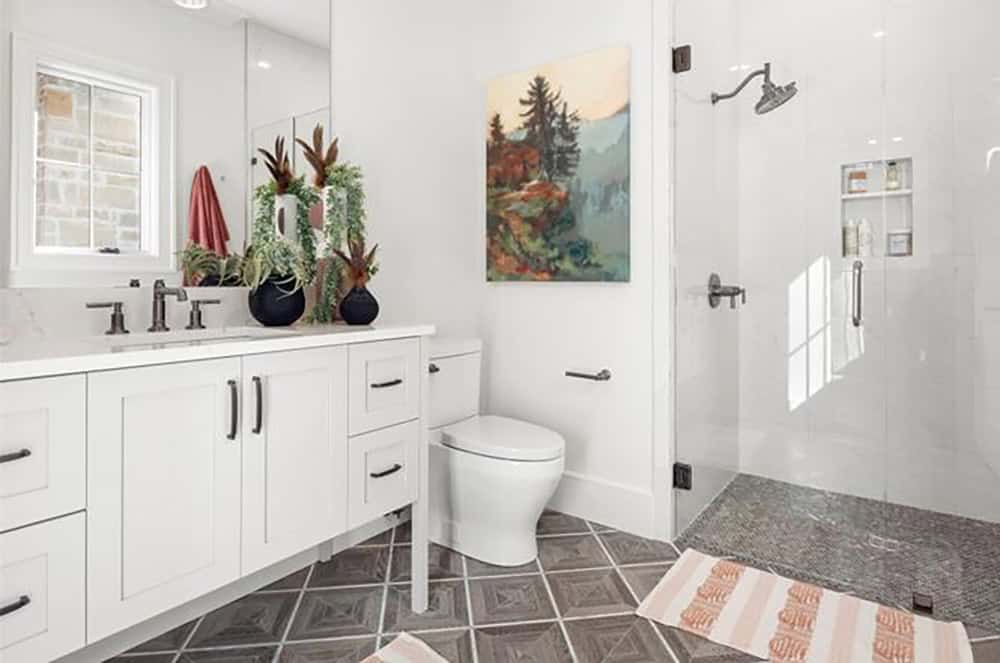 Bathroom with white shaker cabinets, dark matte fixtures, geometric floor tile, and glass walk-in shower