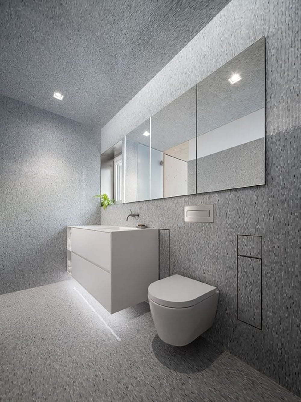 Modern bathroom with floor-to-ceiling gray mosaic tile, floating vanity, and wall-hung toilet