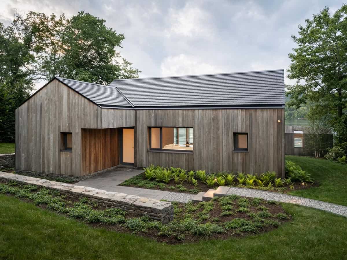 Exterior of prefab Connecticut lake house with weathered cedar cladding and slate roof