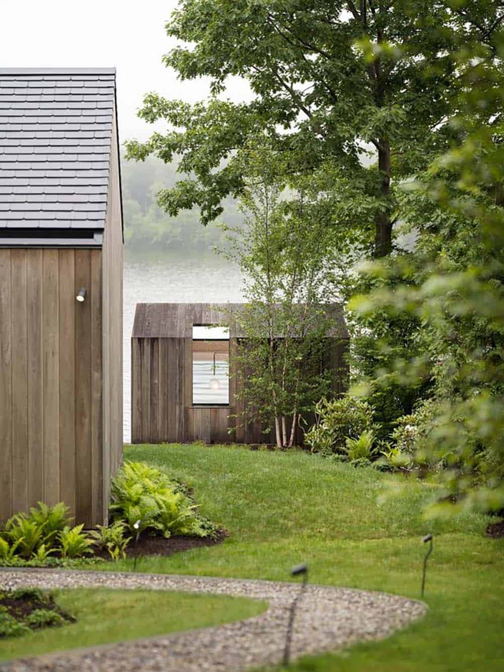 View across landscaped grounds to the detached CLT studio near the Connecticut lakefront on a misty day