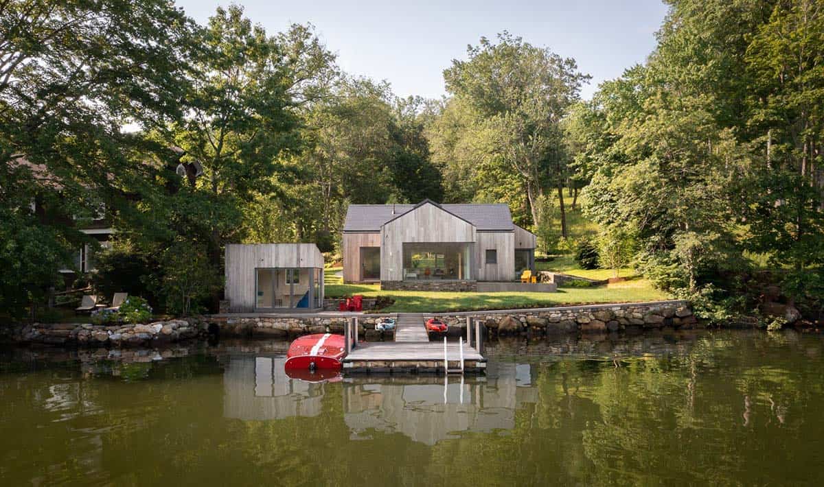Daytime aerial view of prefab cross-laminated timber lake house in Connecticut reflected in calm water
