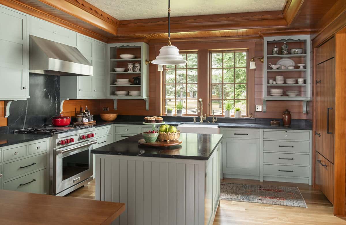 Kitchen with sage green cabinets, soapstone countertops, farmhouse sink, and Wolf range