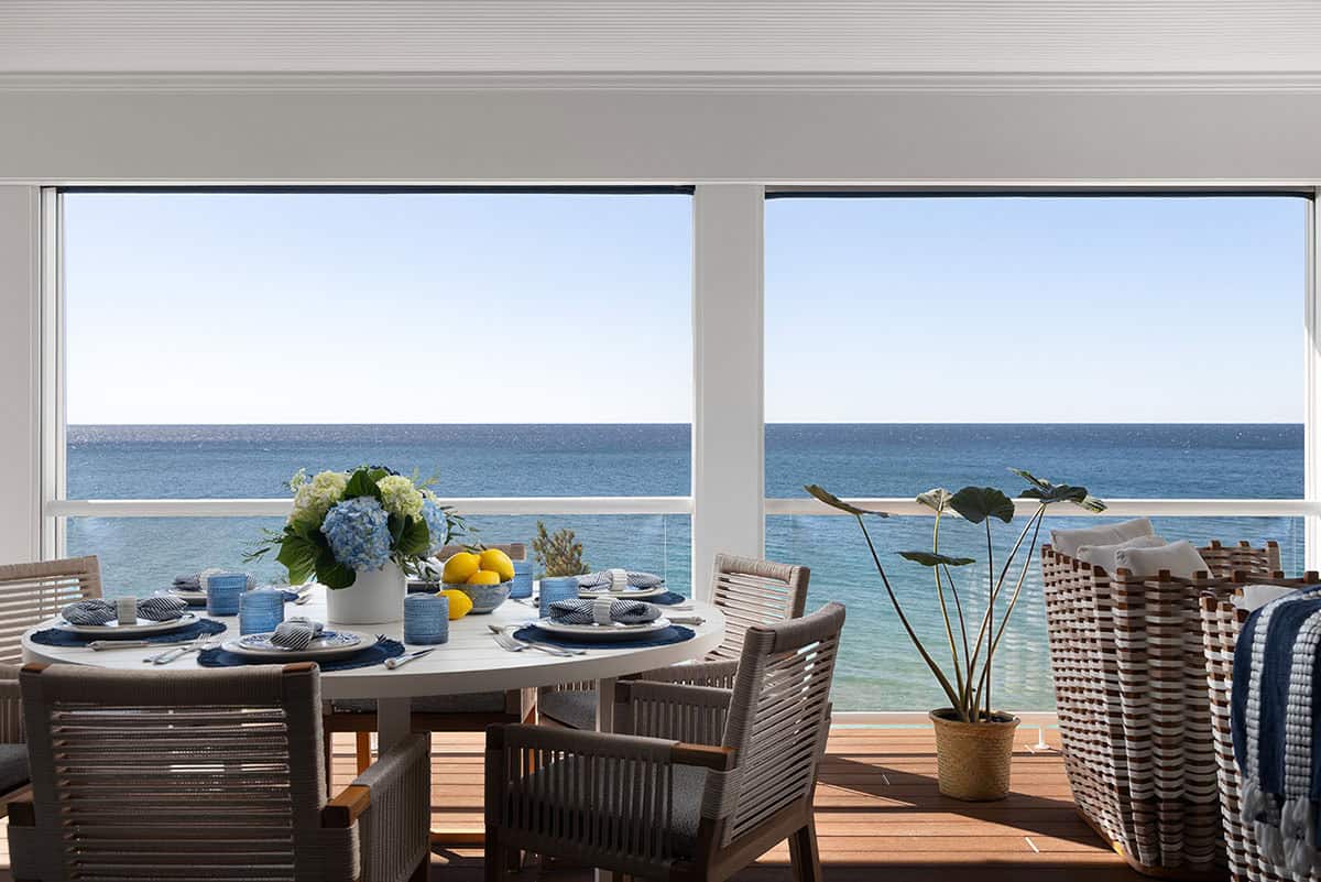 Outdoor dining table set with blue and white tableware and lemons, overlooking the open lake