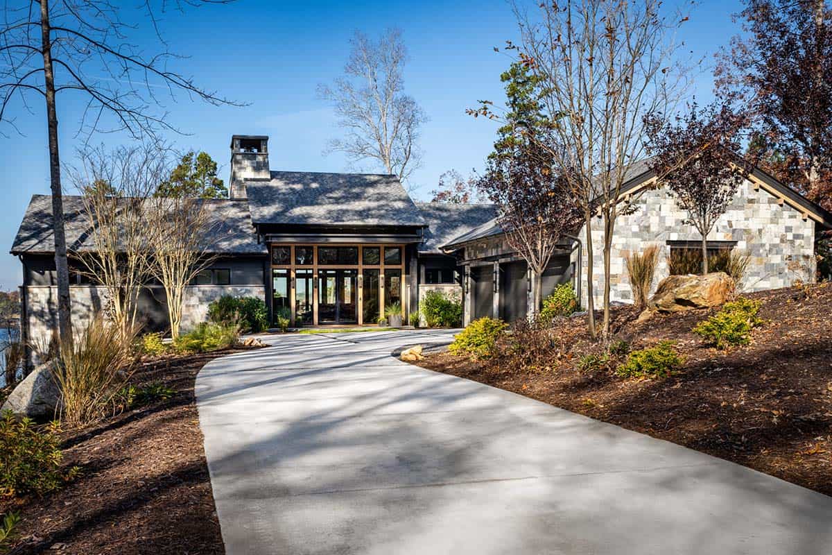 Driveway approach to lake house with stone facade and wood-trimmed entry