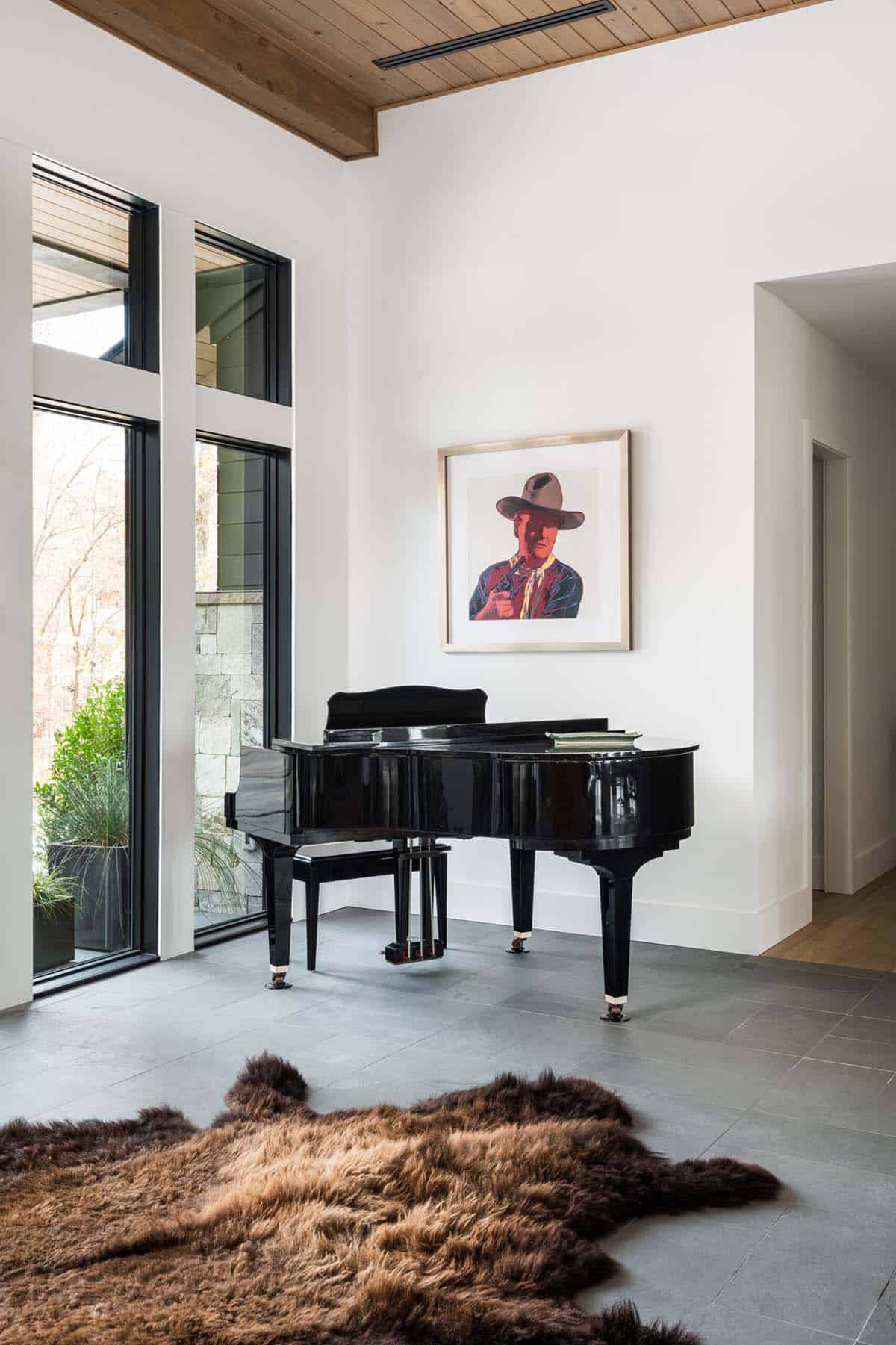 Grand piano beneath framed pop art portrait in vaulted entryway