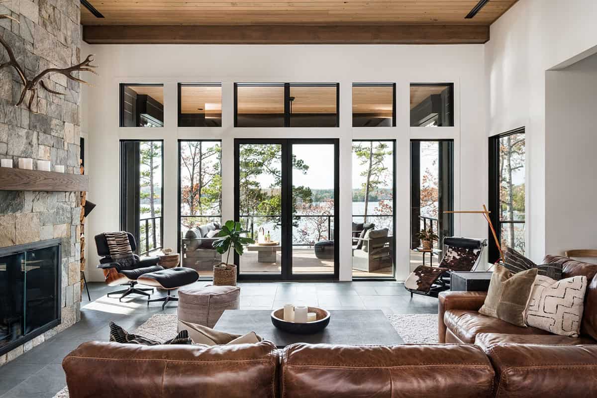 Living room with leather sofas and glass doors opening to lake-view deck