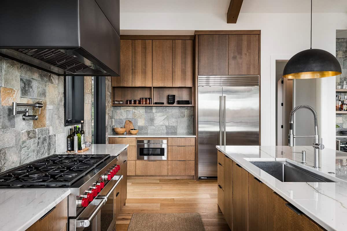Kitchen with stone backsplash, wood cabinetry, and stainless steel appliances