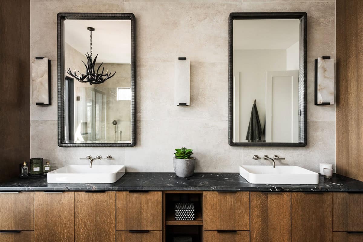 Bathroom vanity with dual vessel sinks and dark-framed mirrors