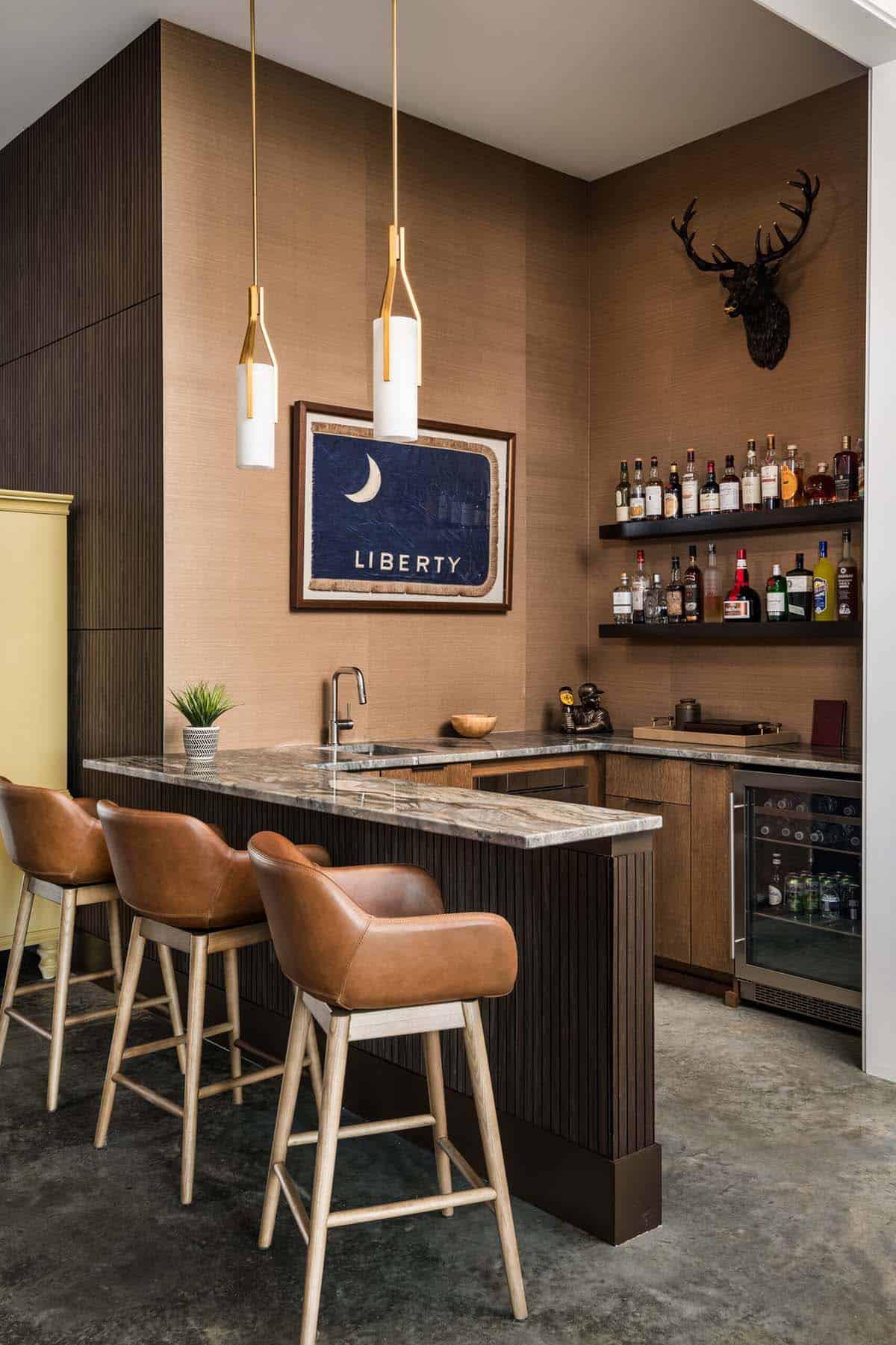 Wet bar with marble counter and mounted deer head decor