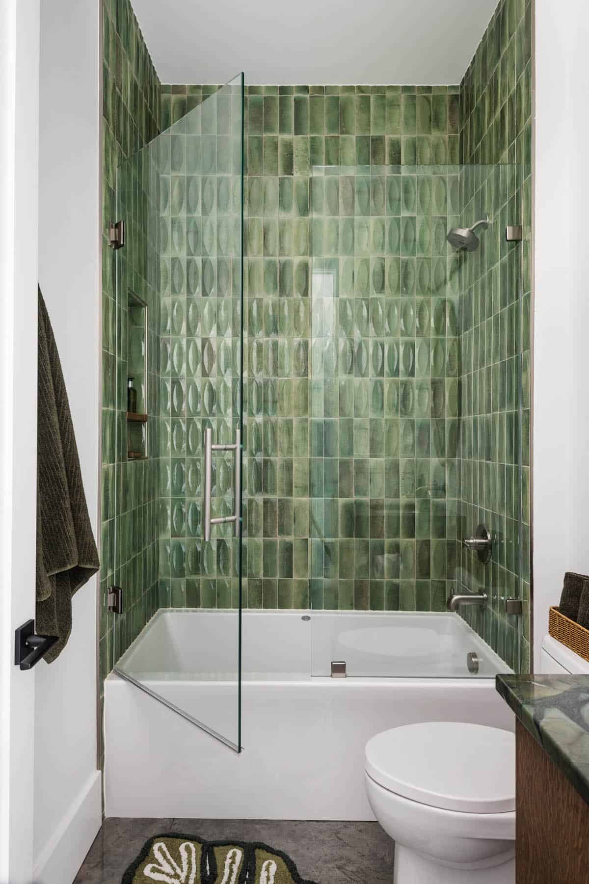 Bathroom with green vertical tile surround on tub-shower combo