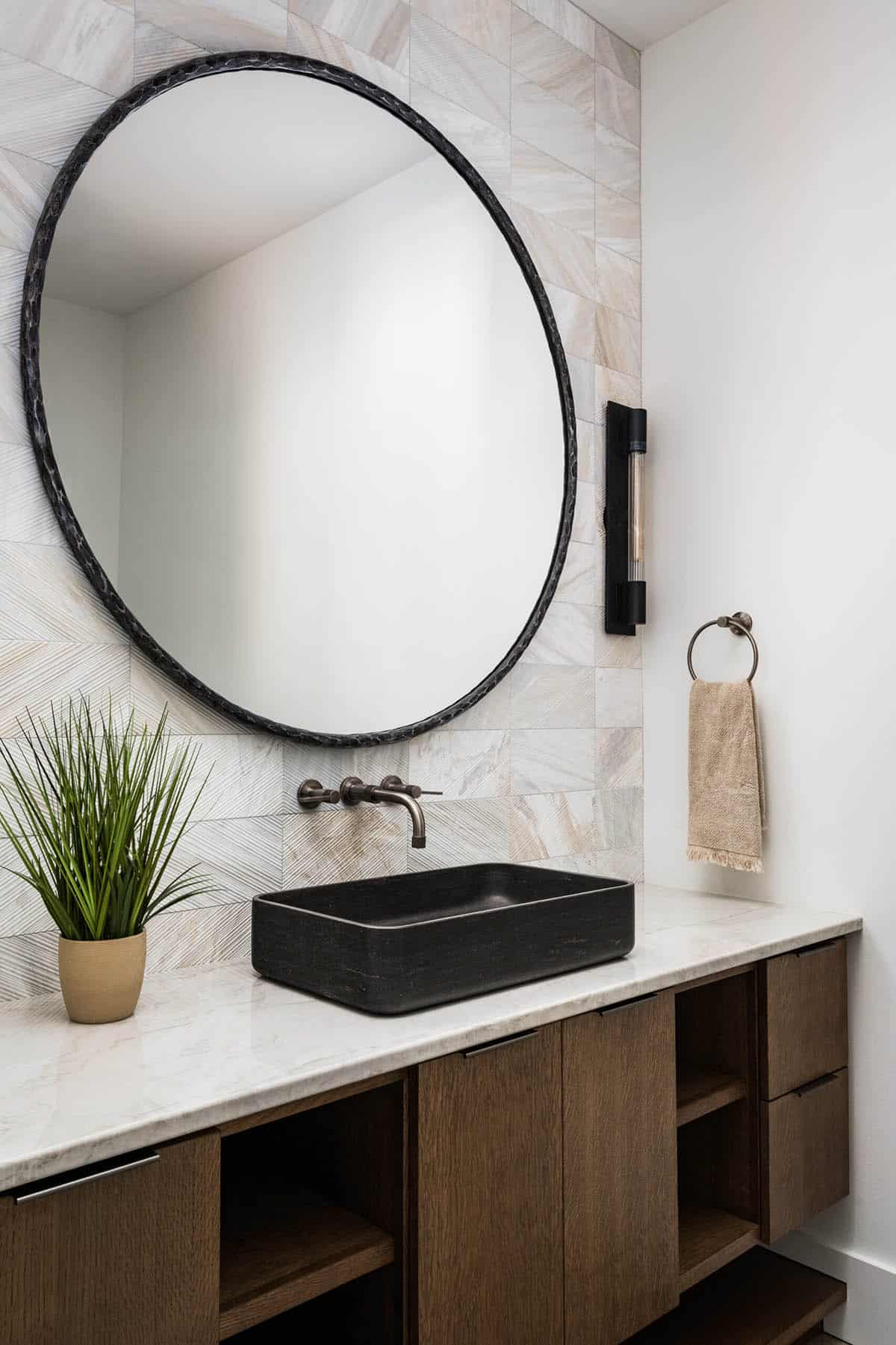 Powder room with round mirror and black rectangular vessel sink