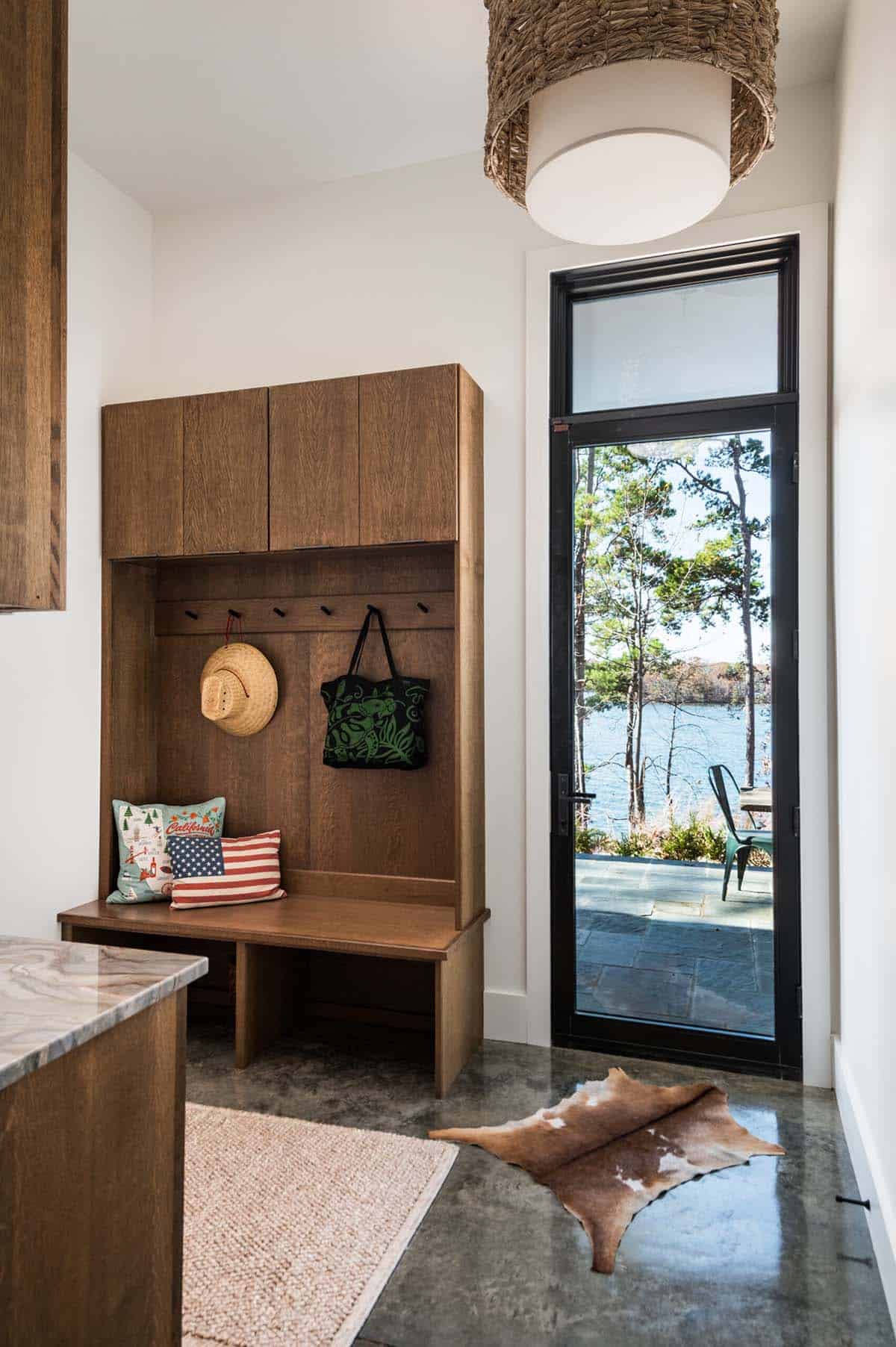 Mudroom nook with wood cubbies and glass door to lake patio