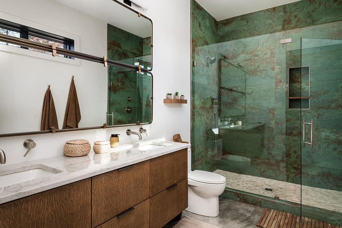 Bathroom with oxidized green metallic tile in glass shower enclosure