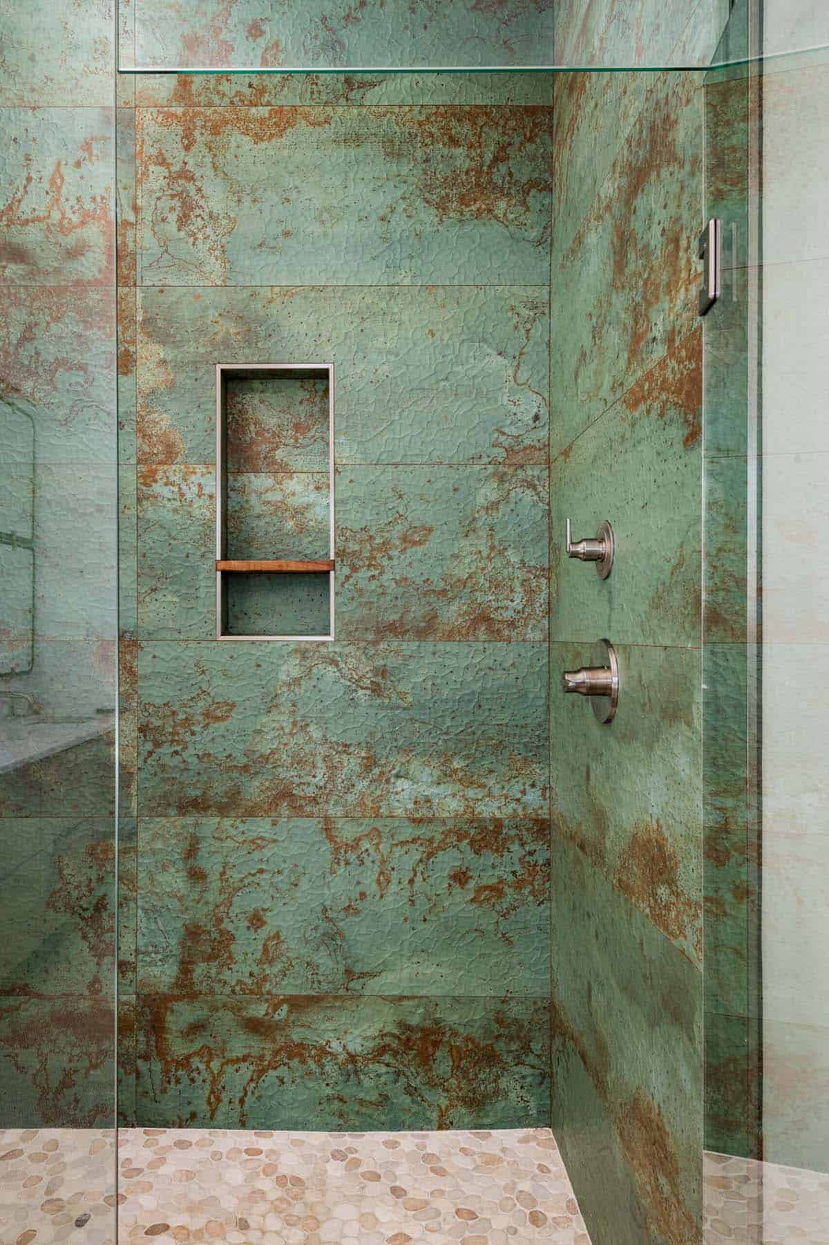Close-up of weathered green-patina tile shower wall and niche