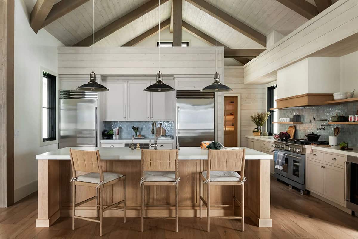 Kitchen island with woven barstools under vaulted beamed ceiling