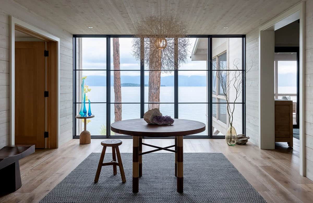 Round entry table framed by floor-to-ceiling lake-view windows