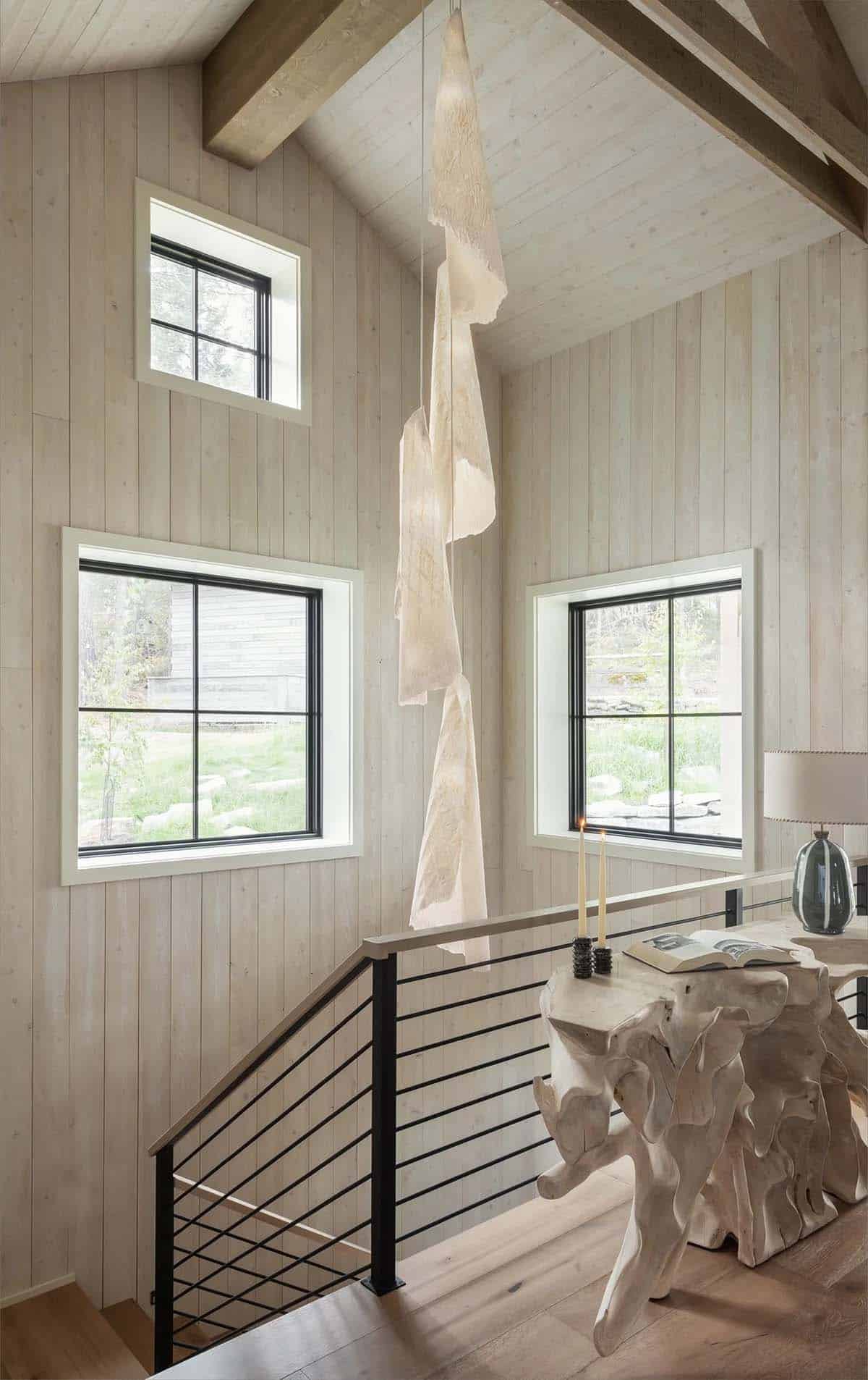 Stairway landing with sculptural wood console and pendant