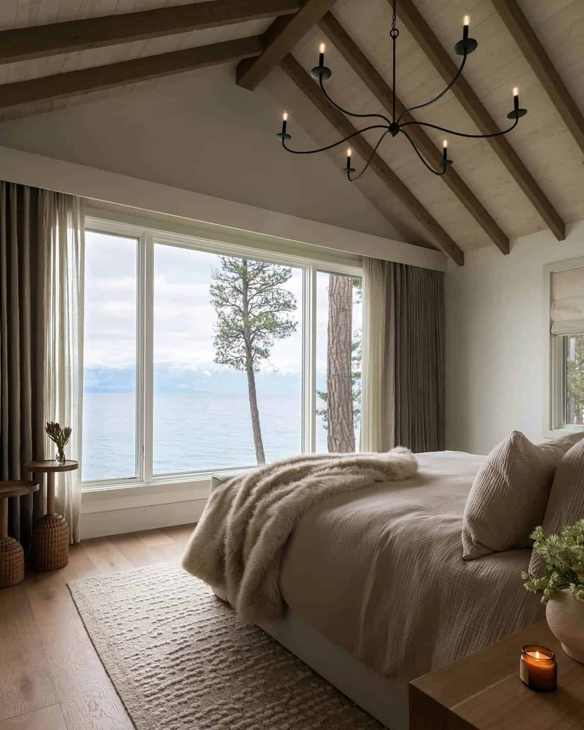 Bedroom with wrought iron chandelier and lake views