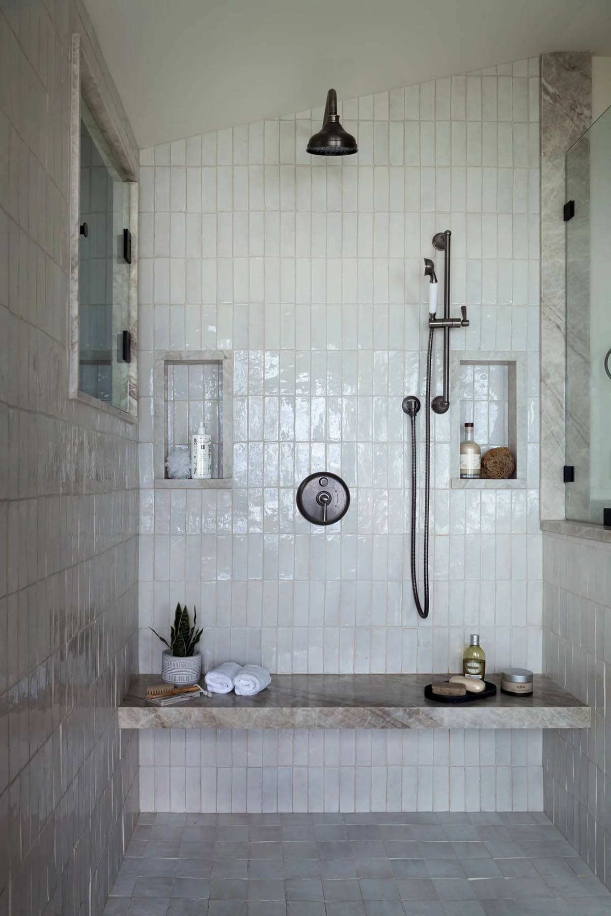 Walk-in shower with vertical tile and built-in niches