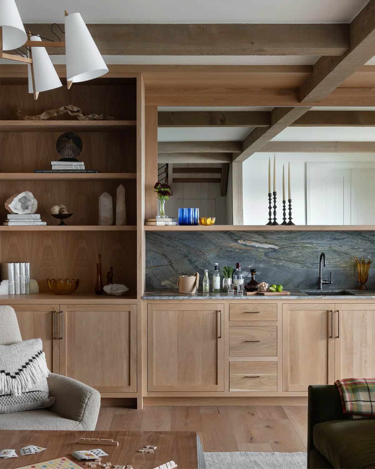 Wet bar with stone backsplash and built-in bookshelves