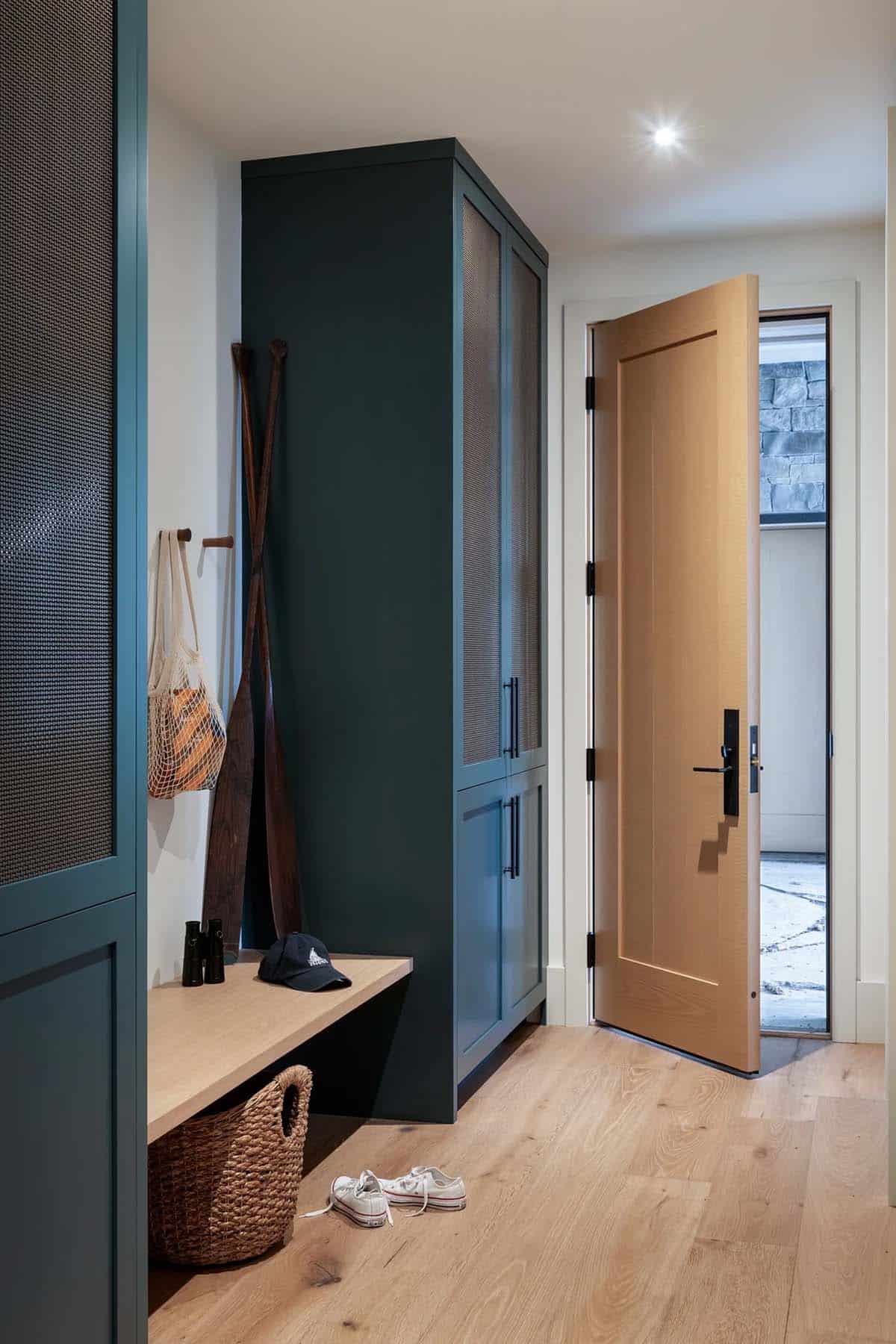 Mudroom with teal cabinetry and oars on display