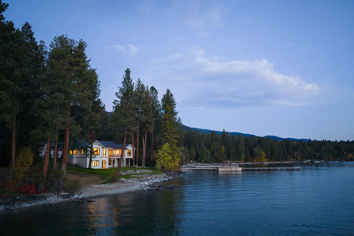 Lake house exterior glowing at dusk along the shoreline