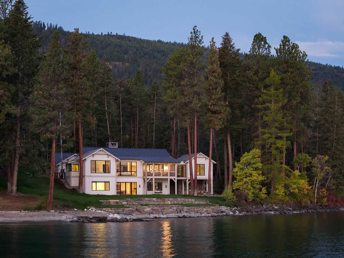 Rear exterior of the lake house illuminated at twilight