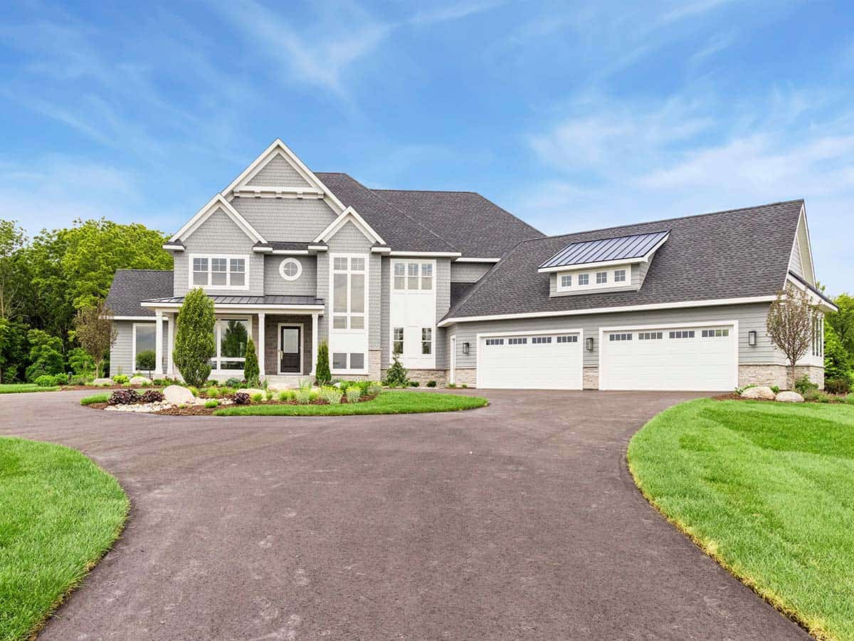 Gray contemporary luxury home exterior with circular driveway and three-car garage