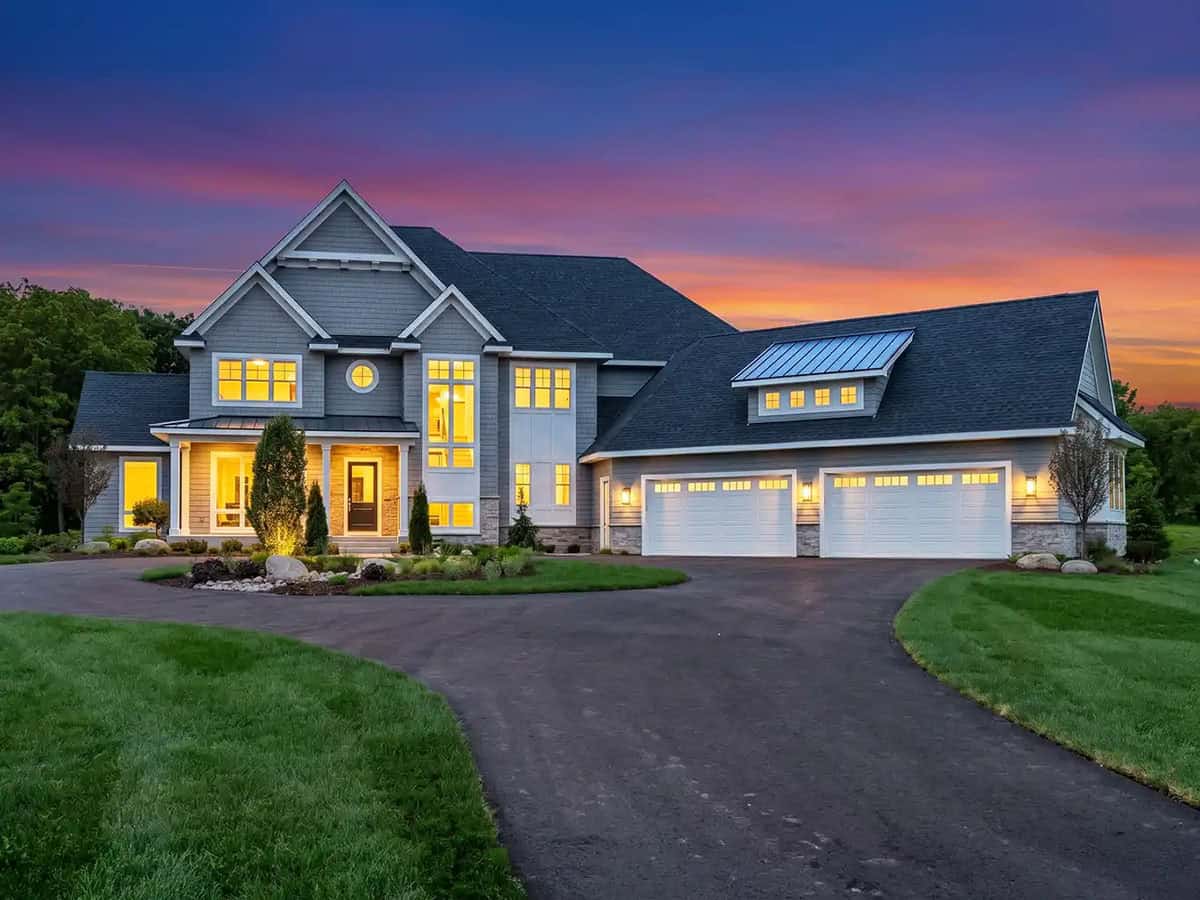  Luxury home exterior glowing at dusk with sunset sky