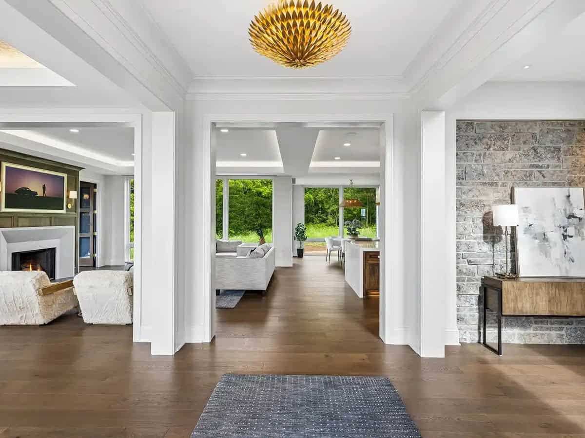 Open-concept foyer with stacked stone wall and view into living room