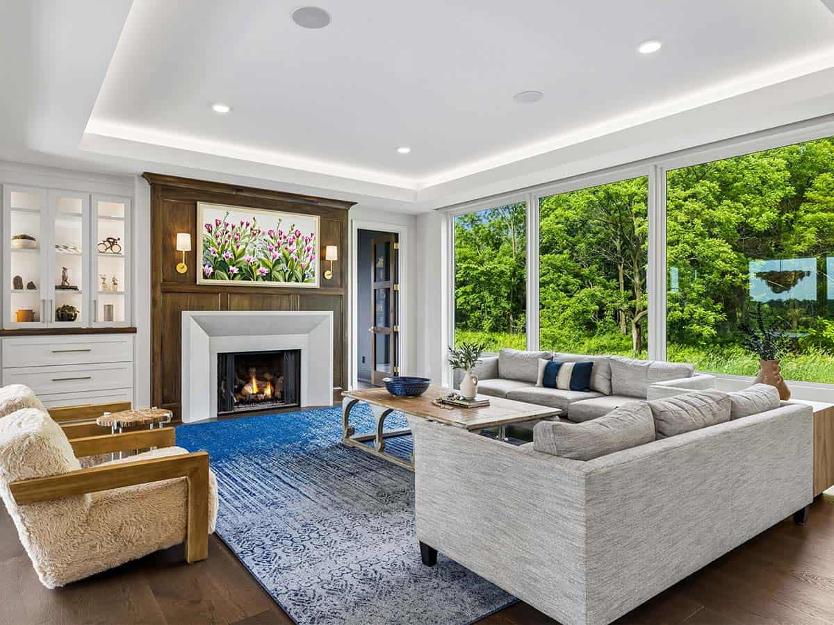 Living room with fireplace, sectional sofa, and floor-to-ceiling windows