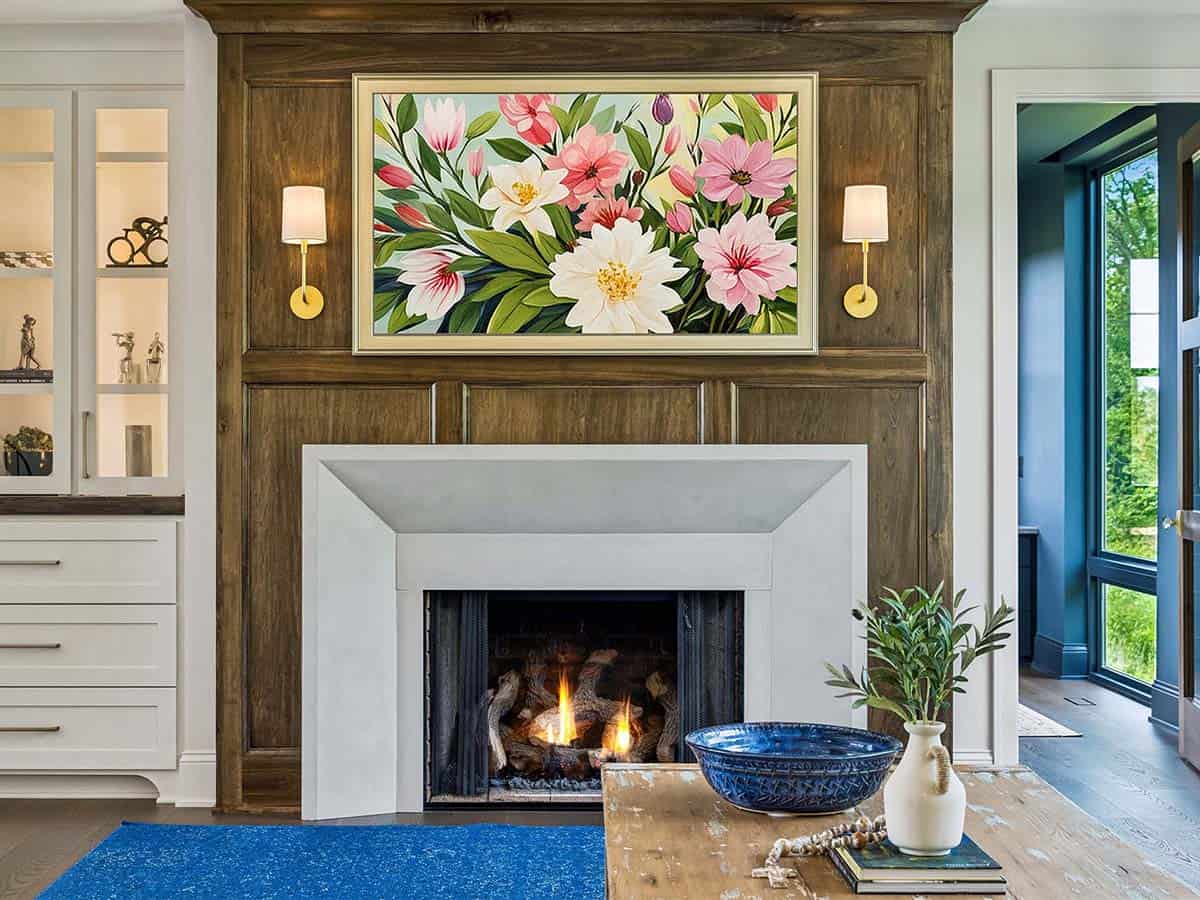 Close-up of fireplace mantel with floral art and brass sconces