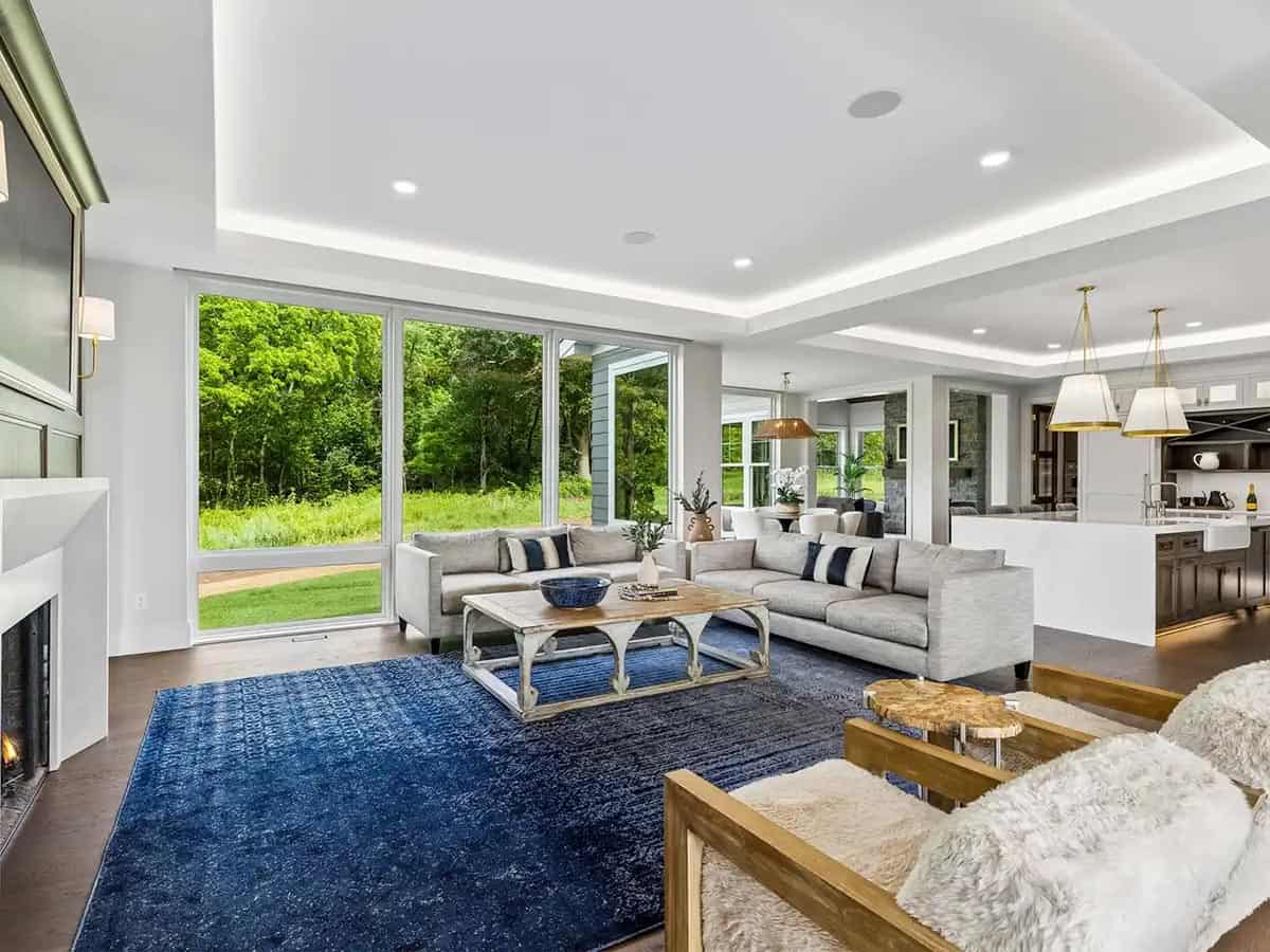 Open living area with blue rug, sectional, and view into kitchen