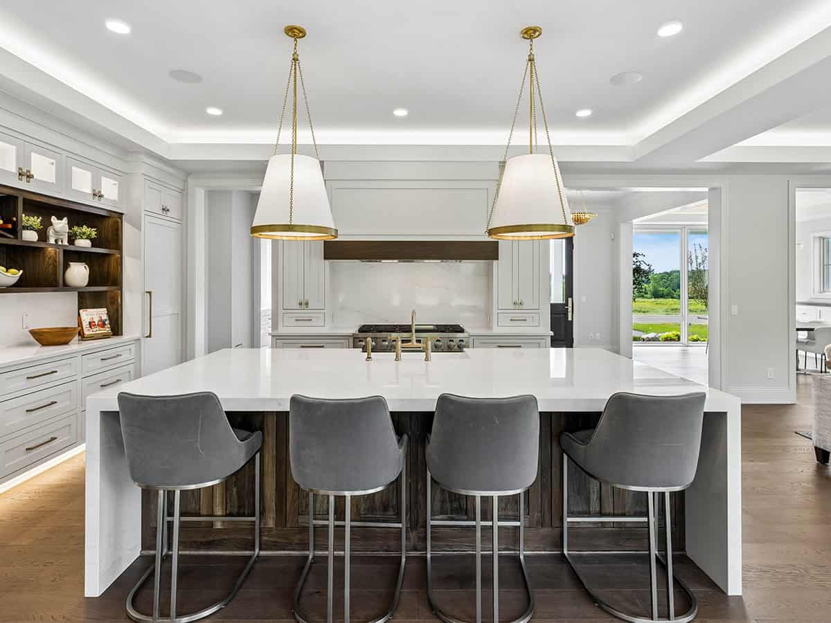 Kitchen island with brass pendants and view through to entry