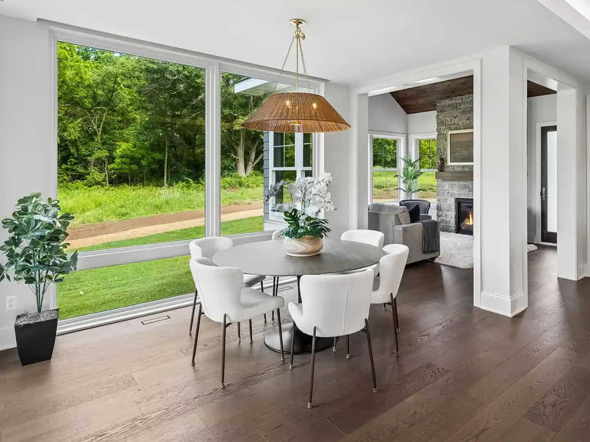 Breakfast nook with round table and woven pendant light overlooking yard